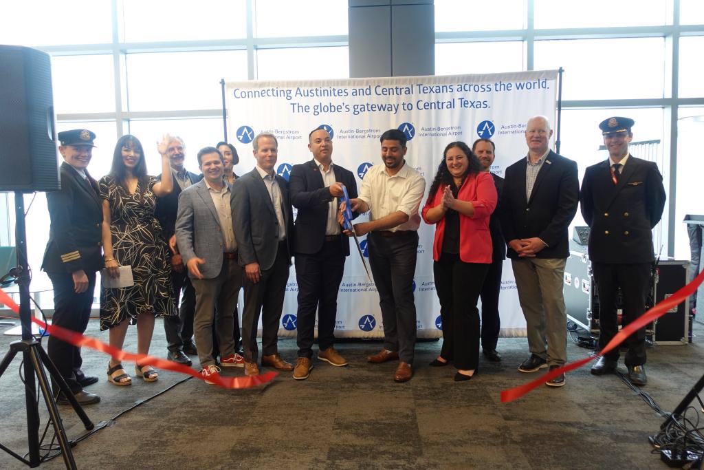 People standing and cutting a ribbon.