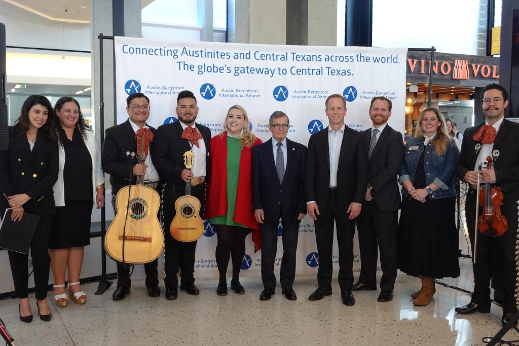 Photo of airport and City leadership, Mexican Consul and other visitors posing for a picture at the Viva Aerobus launch at AUS.