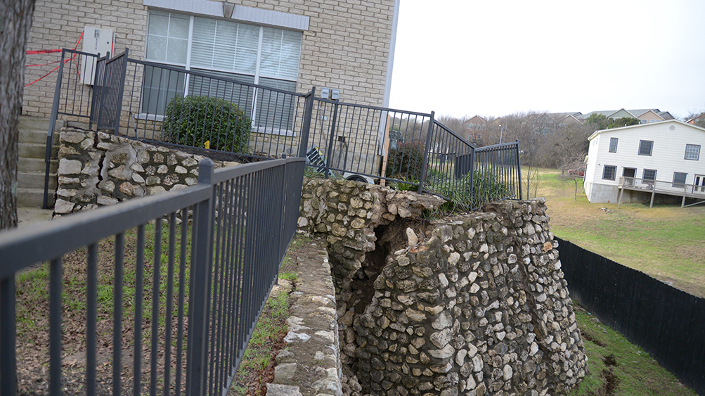 collapsed concrete structure in front of an apartment entrance