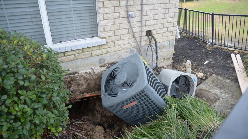 air conditioning unit collapsed into a sinkhole near an apartment building