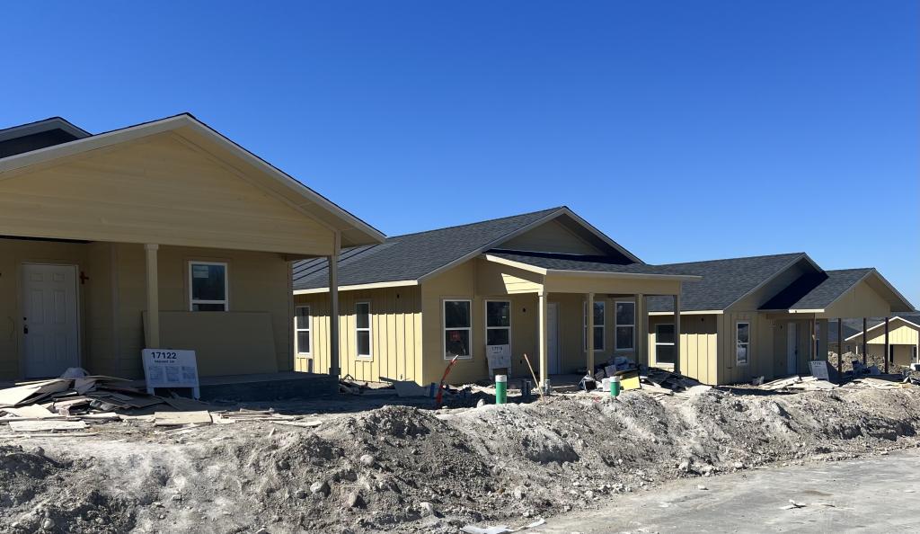 Image shows several Austin Habitat one-story single family homes under construction in Whisper Valley.