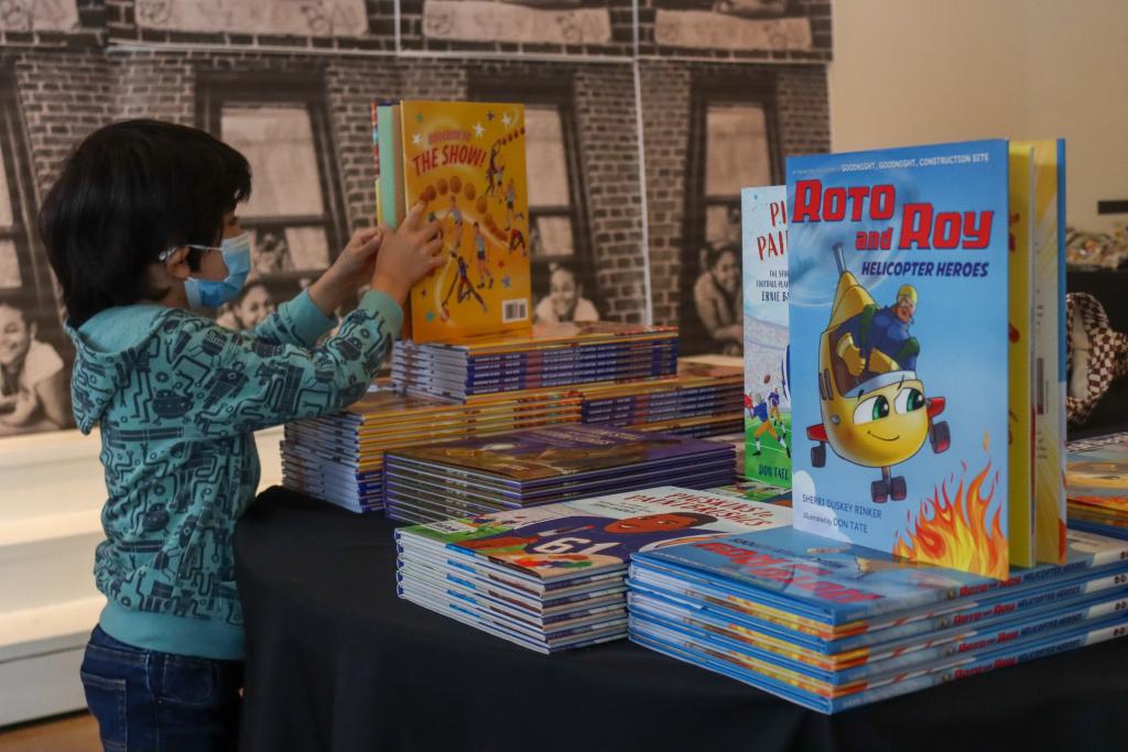 photograph of a child standing in front of a book display