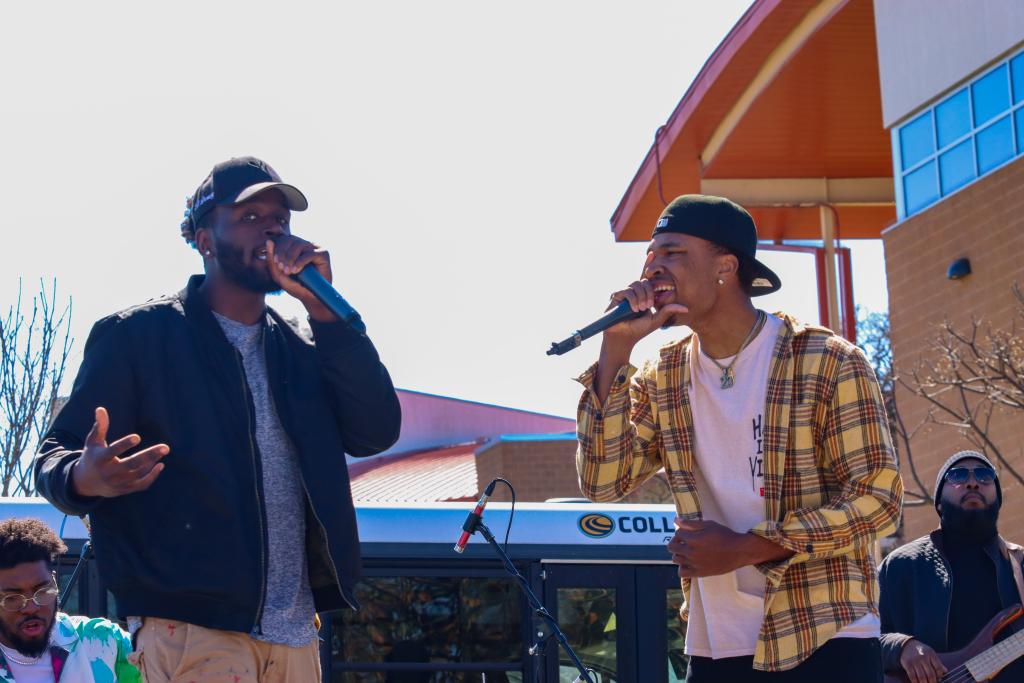 photograph of two performers on stage in front of the museum