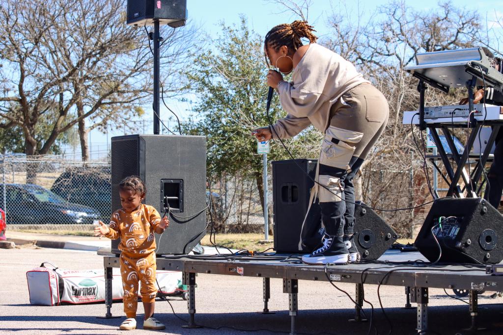 photograph of Shelbi Alexander performing on stage and a child dancing in front of the stage