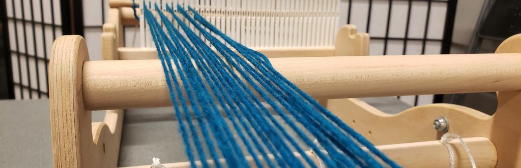 waeving loom in use with blue yarn.