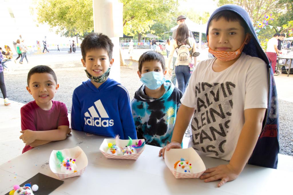 Kids attending the Day of the Dead celebration in 2021 showing off their sugar skulls 
