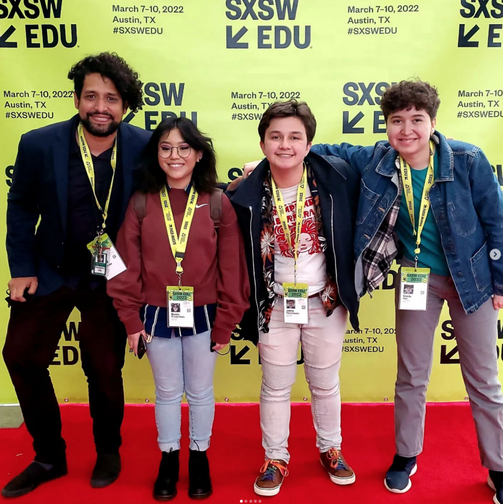 Members of the Caminos Teen Program posing in front of a step and repeat banner at South by South West 2022