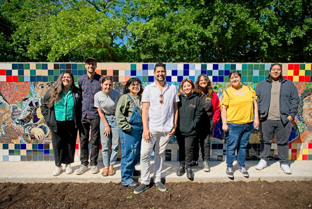 Photo of former Caminos coordinator artist J muzacz MACC site manager Michelle Rojas and previous Caminos students stand in front of the La Mujer mural 