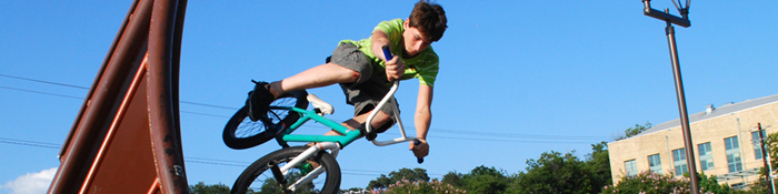 Boy riding a bike down a ramp