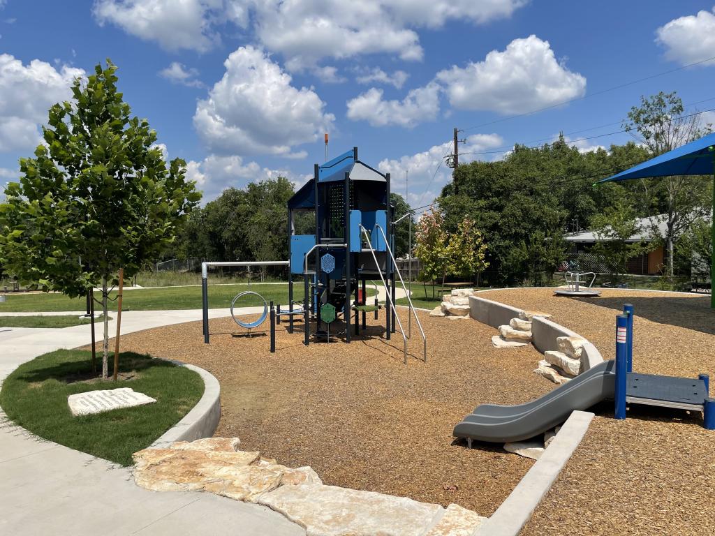 Photo of the new playscape at Scenic Brook park, which includes slides, climbing features, and shade structures.