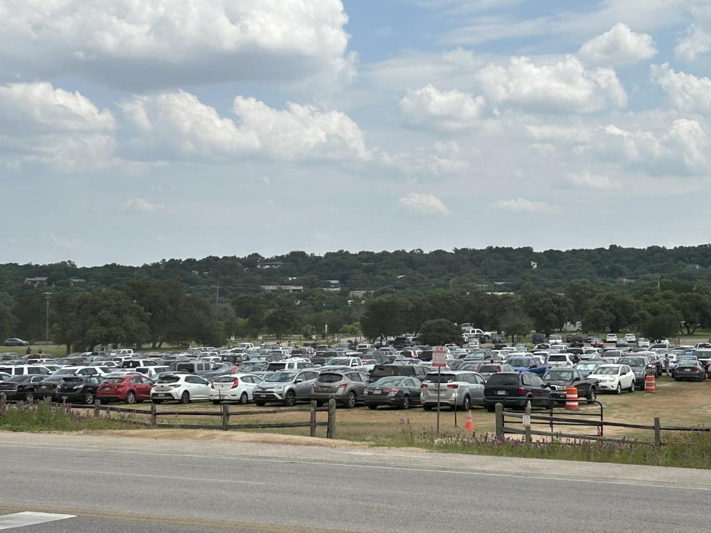 Images showing many cars parked on Polo Field lawn at Zilker Park