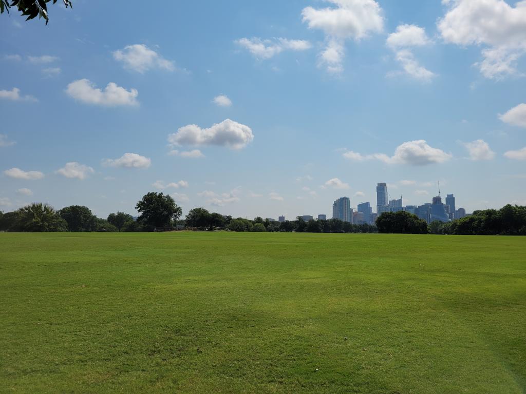 Image of Great Lawn of Zilker Metropolitan Park with city skyline in background
