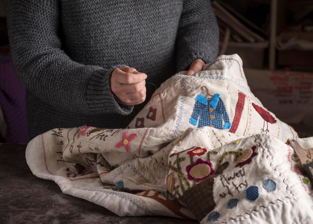 Image of person sewing a holiday blanket