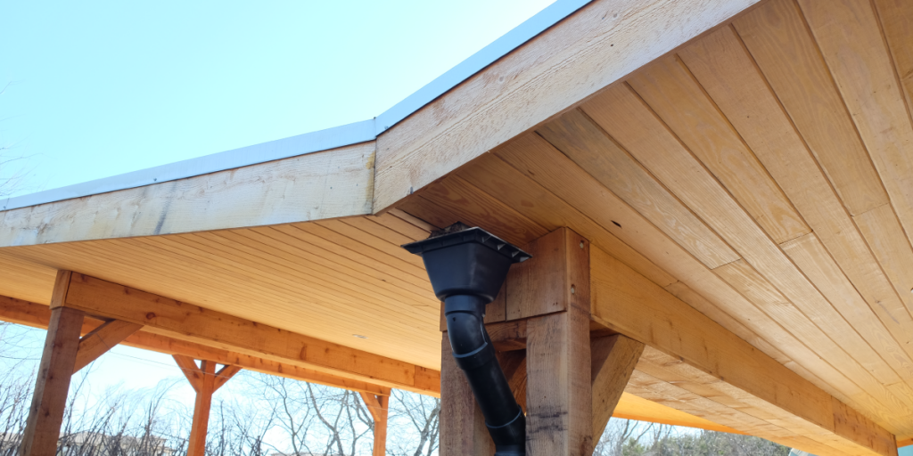 A photo of a gutter coming out from the butterfly-roof of the outdoor classroom.