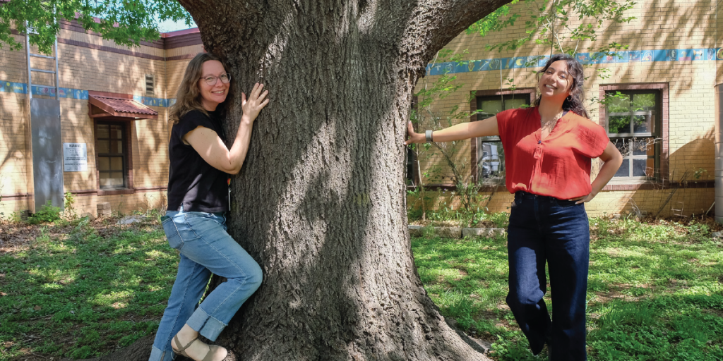 Colleen hugs a tree in the OWL center’s garden and Joanna poses next to her.