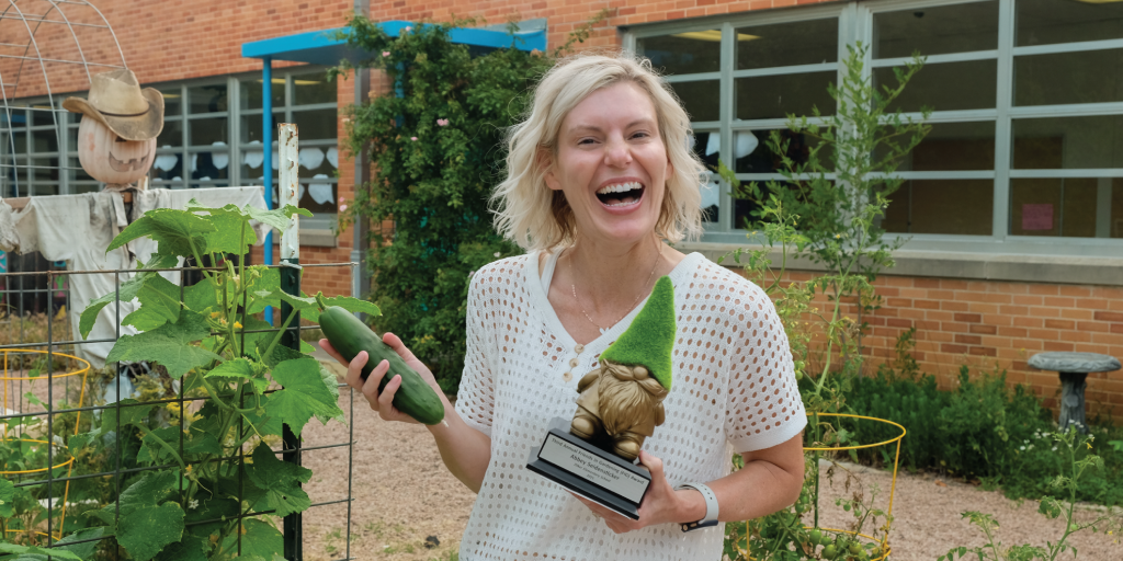 Abbey with the coveted Golden Gnome trophy and a cucumber grown in the Zilker Elementary garden.