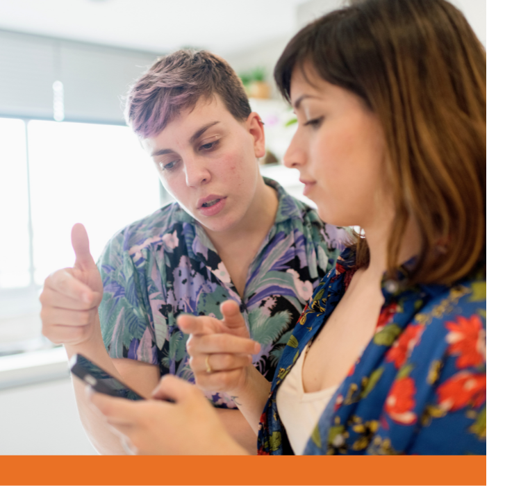 Two people in discussion while looking at a phone.