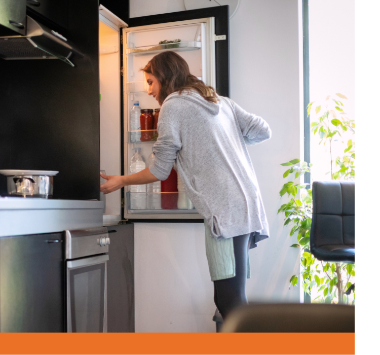 A woman opens the draws in her fridge.