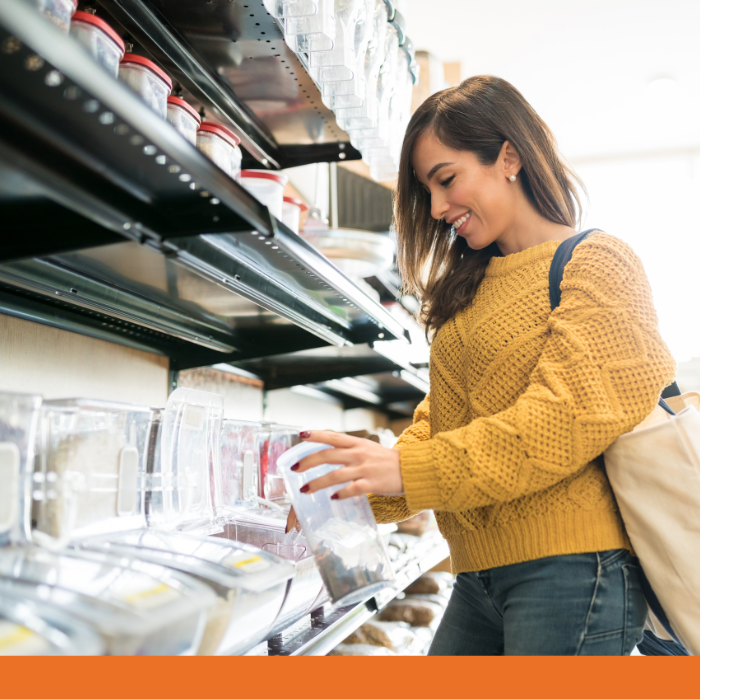 A woman scoops bulk items at the grocery store.