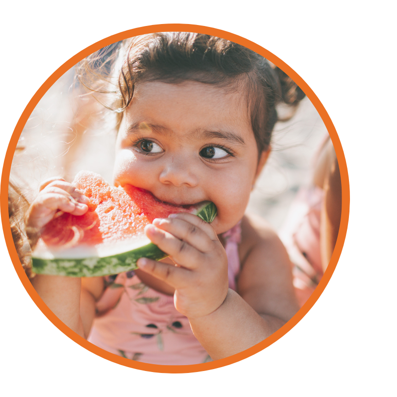 A child eats a large slice of watermelon.