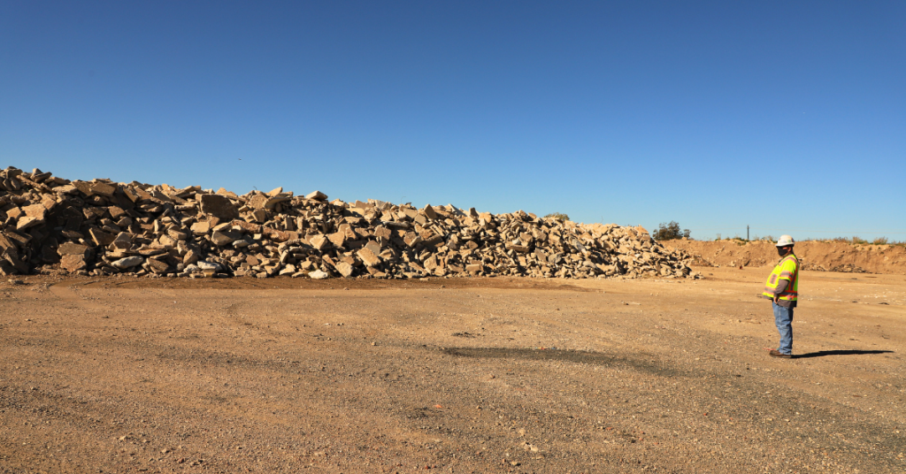 Bobby Currin stands in front of large piles of reclaimed materials.