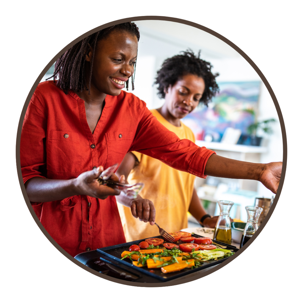 People cooking whole vegetables together in a kitchen.