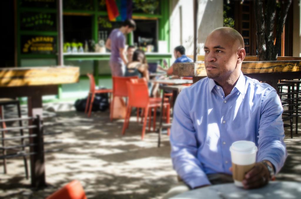 August sits at a coffeeshop downtown.