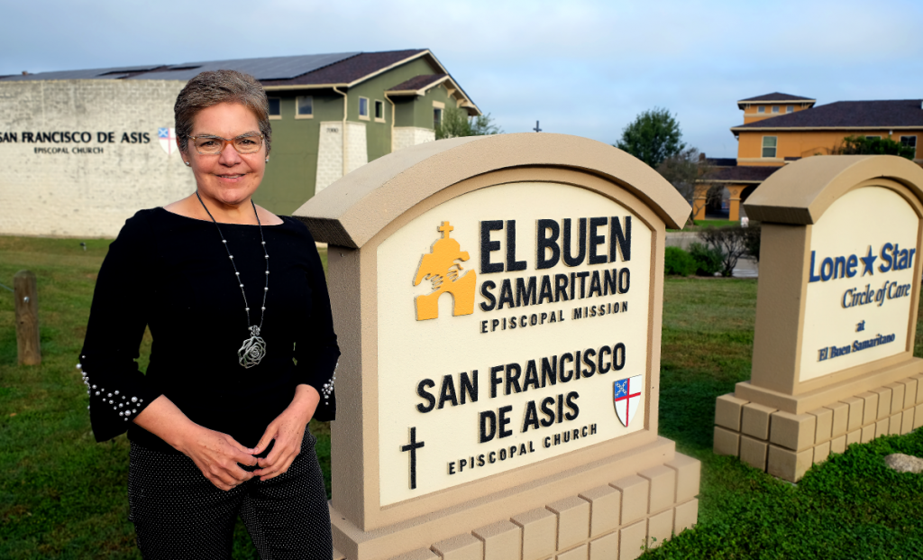 Dr. Murillo stands at the entrance sign to El Buen Samaritano.