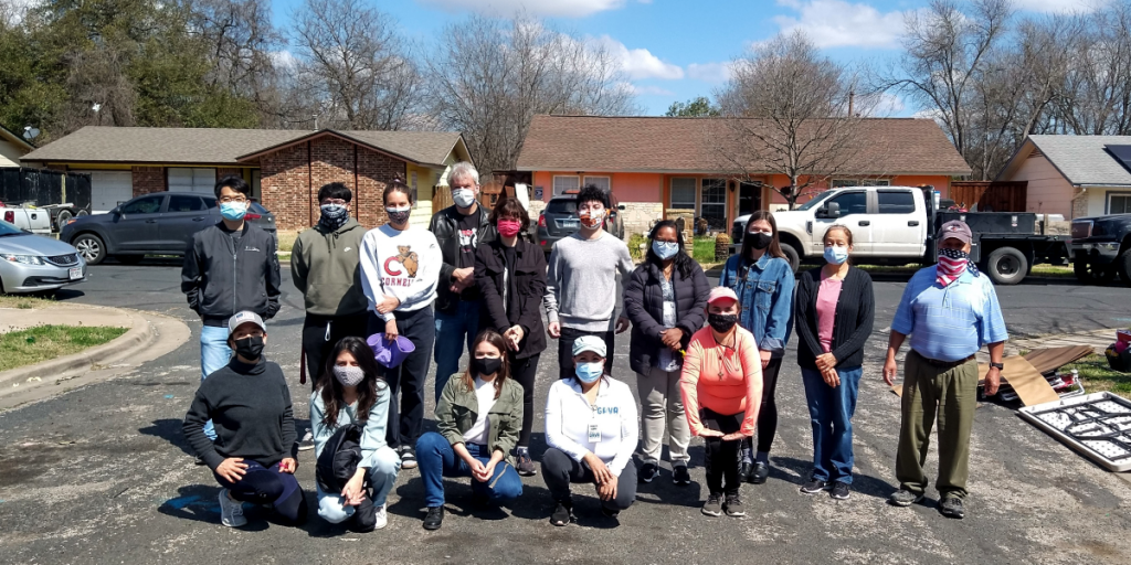 Frances and a group of other folks pose for a photo outside in the Dove Springs neighborhood.