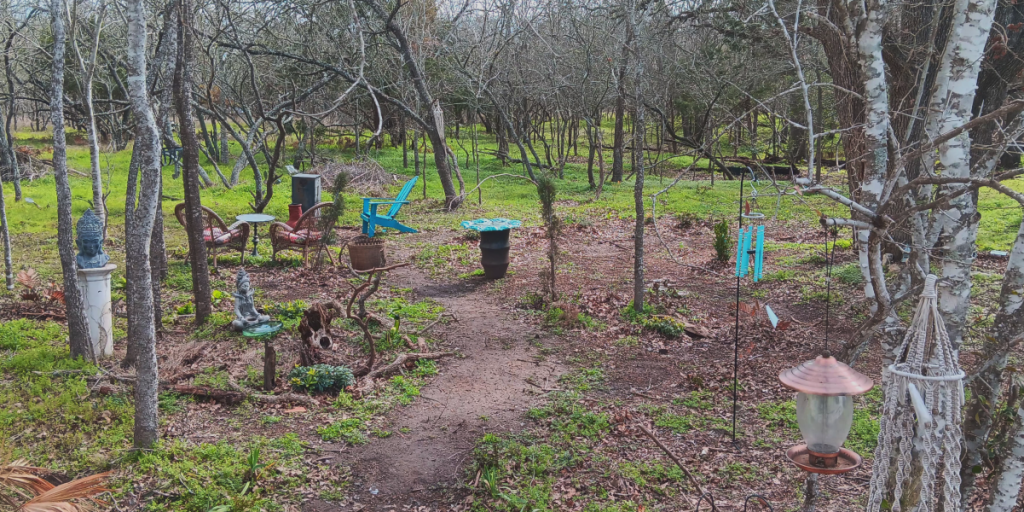 A forested area with sculptures and gathering spaces.