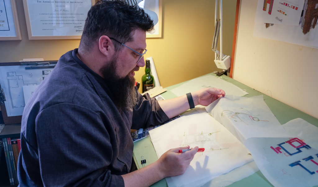Jason sketches at his drafting table in his office.
