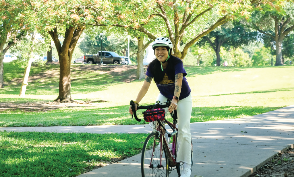 Laura smiles while riding her bike.