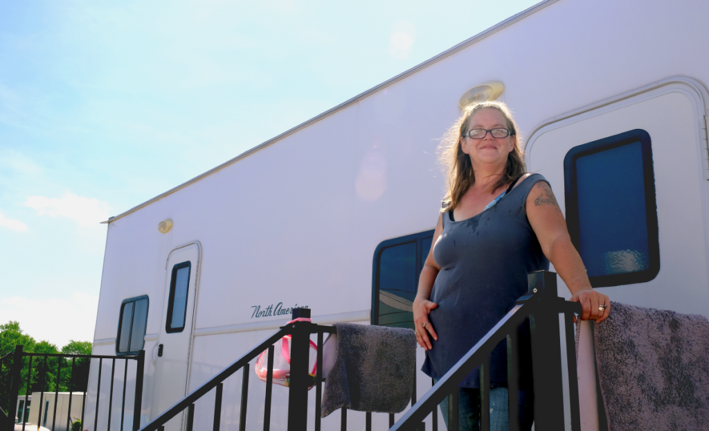 Leatha smiles at the entrance to her home.