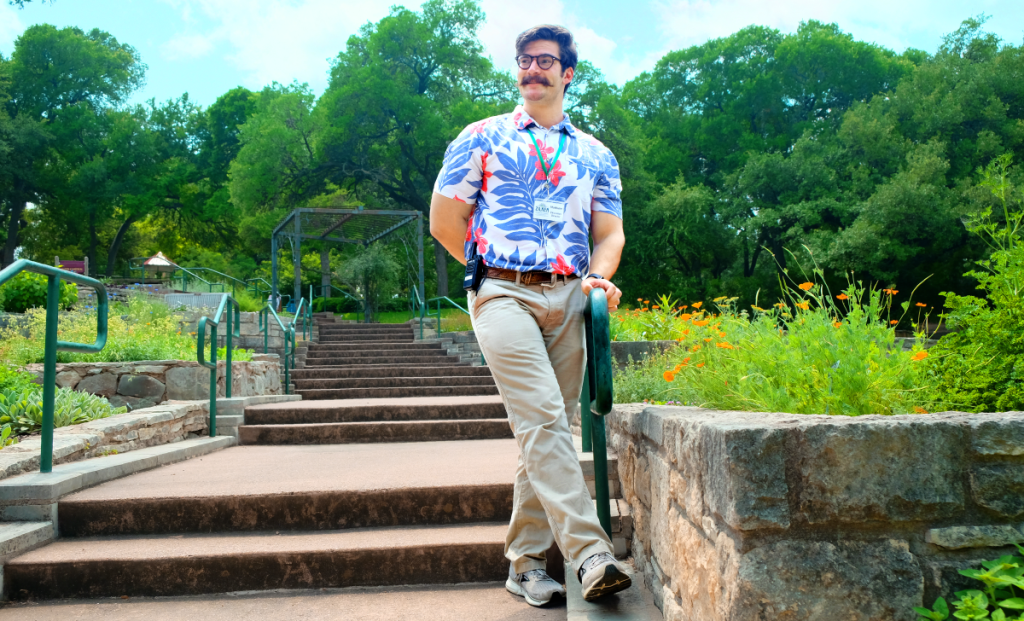 Matthew stands on the bottom of a set of stairs in Zilker Botanical Garden's Herb Garden.