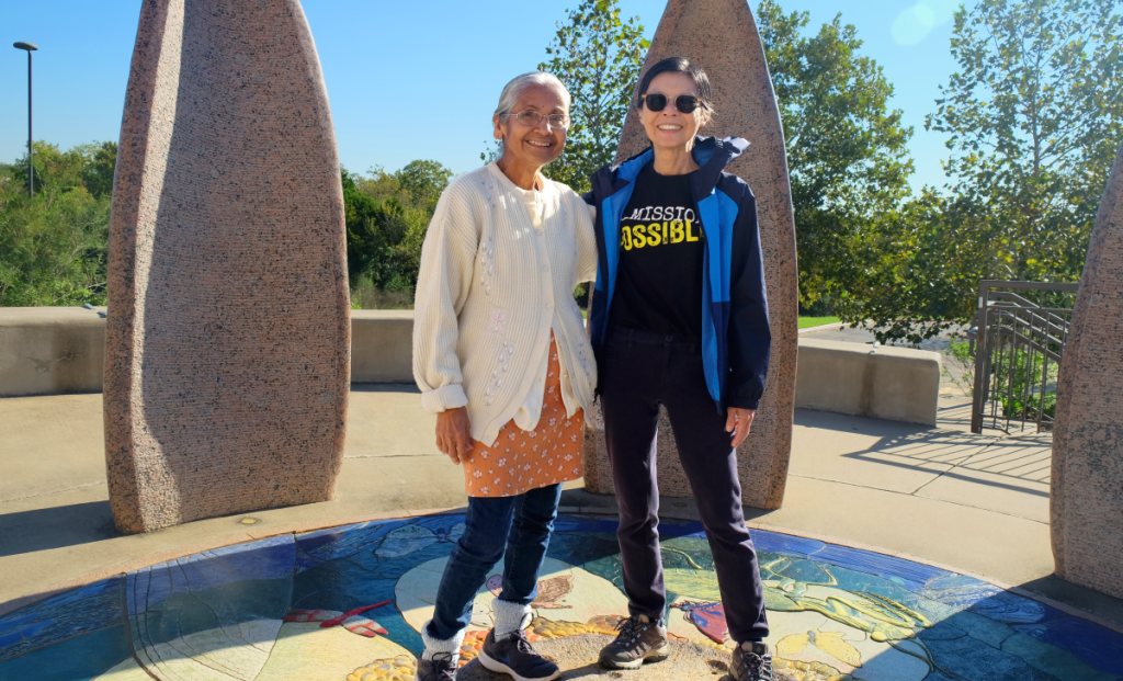 Himadri and Niki stand in the center of an outdoor sculpture at the Asian American Resource Center.
