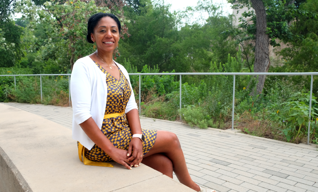 Nitakuwa sits on a bench along the Waller Creek Greenbelt.