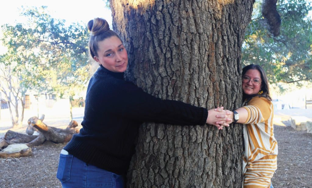 Krysta and Lisa hug the giant live oak tree on Odom’s campus.