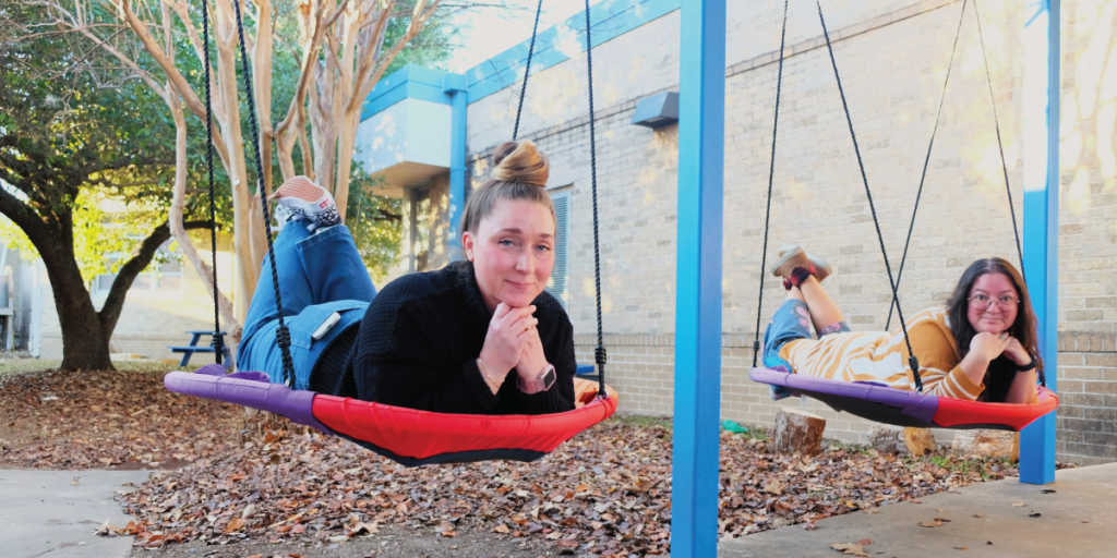 Krysta and Lisa ride on large circular swings in the Odom schoolyard.