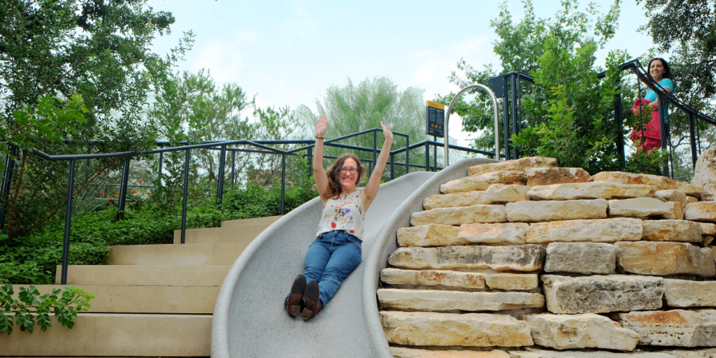 Eileen slides down a large slide at Waterloo Park.