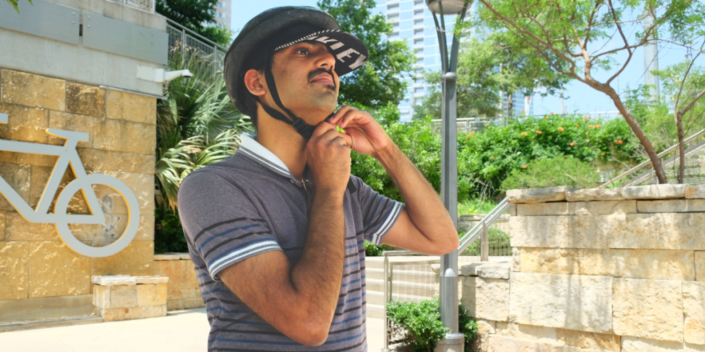 Saket gets ready to ride, strapping on his helmet.