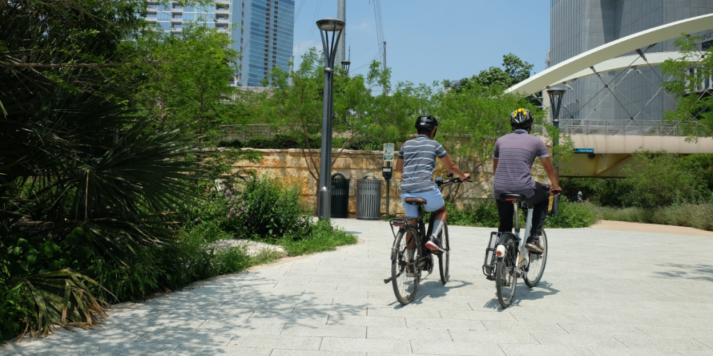 Sagar and Saket ride down the Shoal Creek Trail with their backs to the camera.