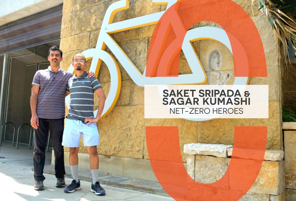 Sagar Kumashi and Saket Sripada stand with arms around each others' shoulders in front of a the bicycle sign at the Central Library.