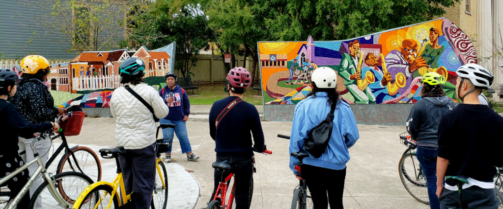 A photo of Stephanie leading a group of Austinites on a bike tour through East Austin.