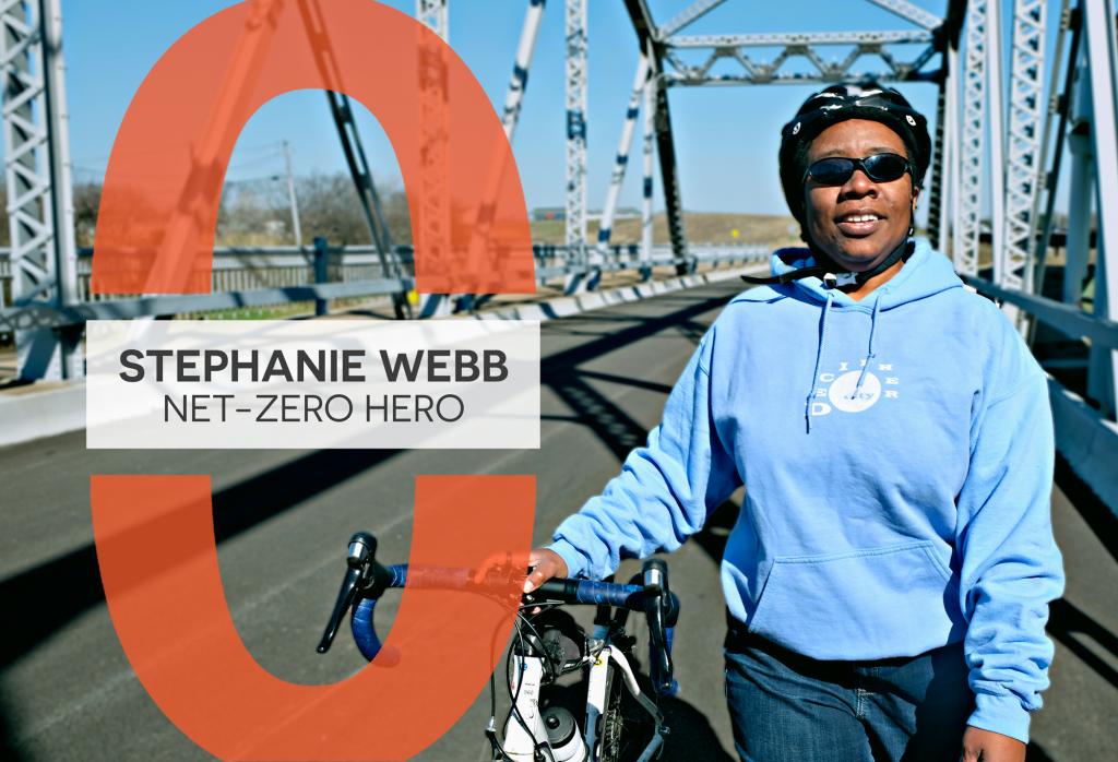 A photo of Stephanie Webb walking on Montopolis Bridge with her bicycle. A graphic on it reads, "Stephanie Webb: Net-Zero Hero".