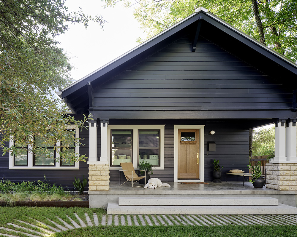 An exterior photo of Trey Farmer's home. A big, white dog lays on the porch.