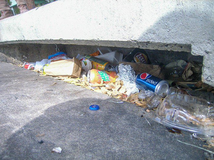 A storm drain full of trash.