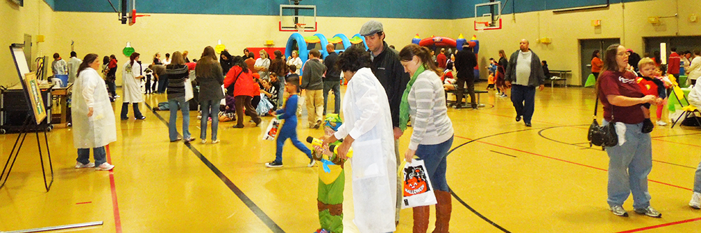 Familie having a fun time playing at different booths at Northwest Halloween community event.