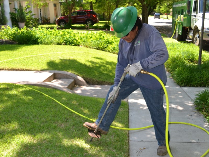 A man fertilizing a lawn with deep-root injection
