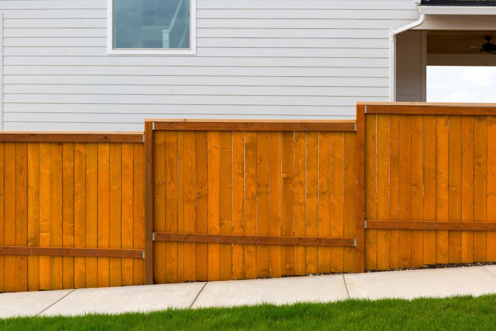 wooden fence sloped downhill in front of a house