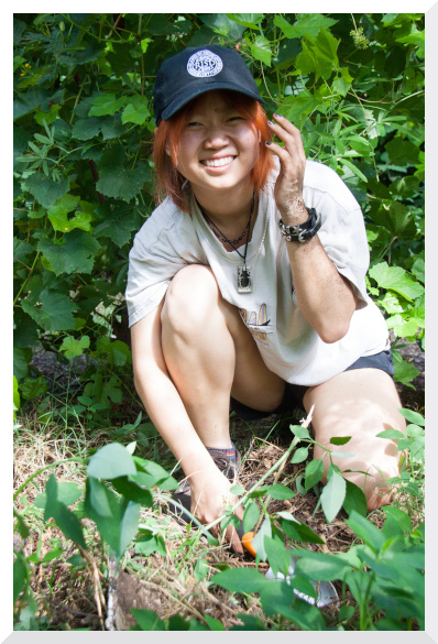 Emma with a hand trowel outdoors during a tree planting project